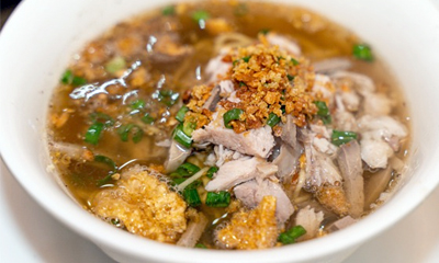 Photo of La Paz Batchoy made from pork offal, beef loin, shrimp broth, and round egg noodles, and served with pork crackling and leek toppings